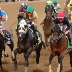 Jockeys racing horses at the Kentucky Derby with grandstands in the background.